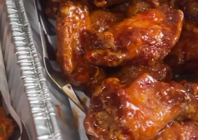 Full catering trays of saucy chicken wings