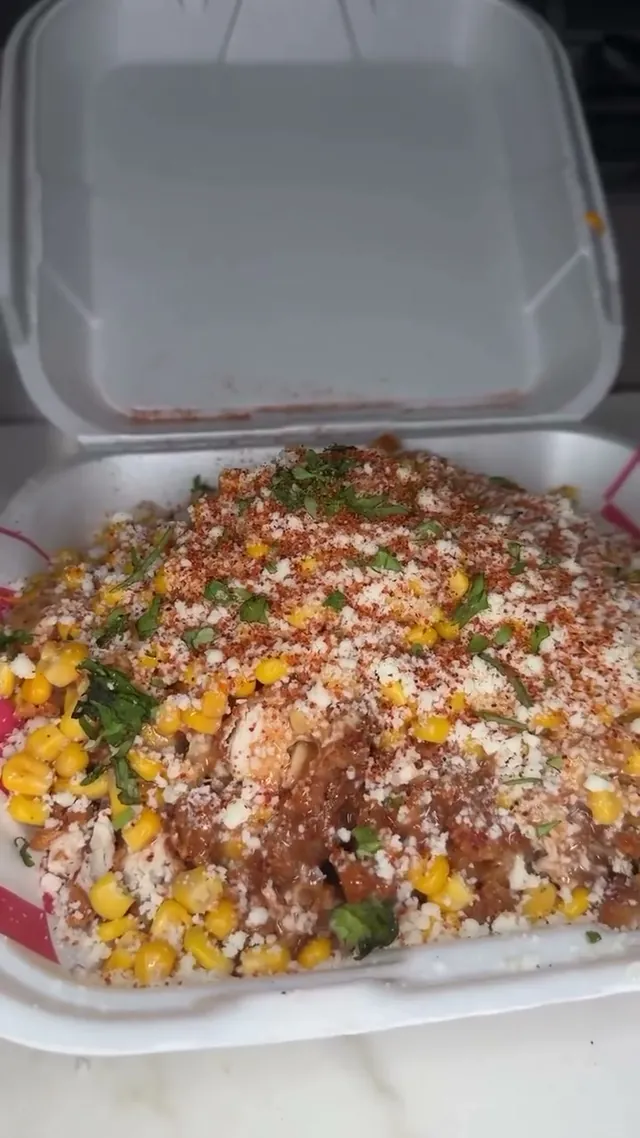 Close up of Elote fries with fried chicken and cotija cheese